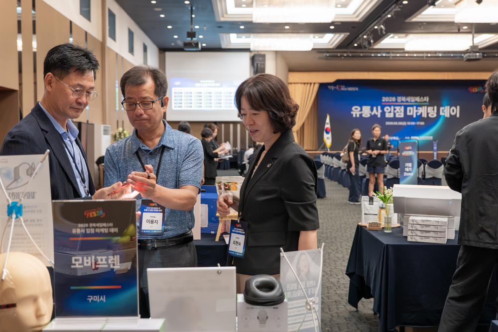전시존에서 제품 설명을 듣는 참관 관계자